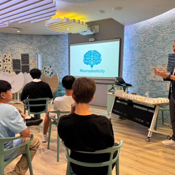 Youth Leadership trainer presents a lecture on neuroplasticity to a group of seated students