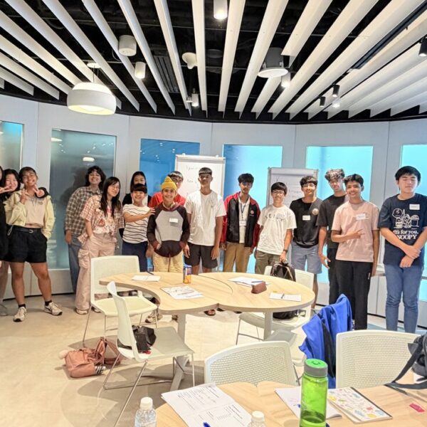 A group of diverse teenagers and two instructors pose for a photo during a Youth Leadership workshop