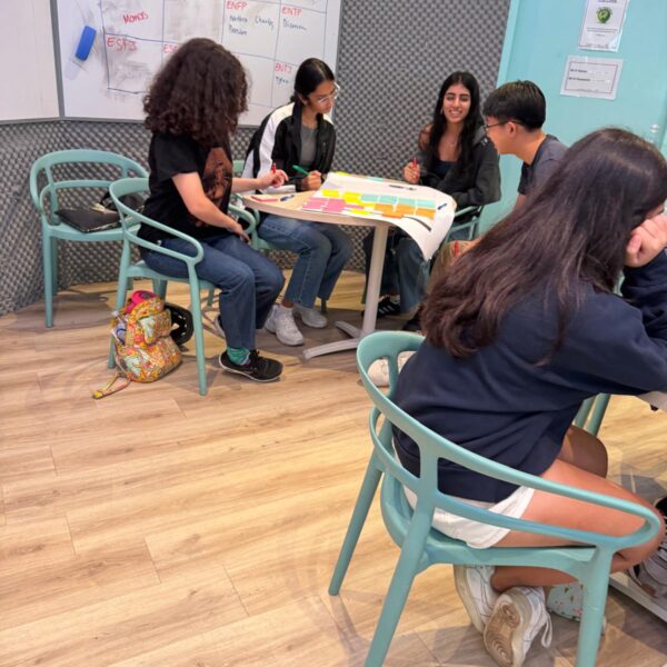 Students collaborating around a table with sticky notes in a Youth Leadership and Communication Camp