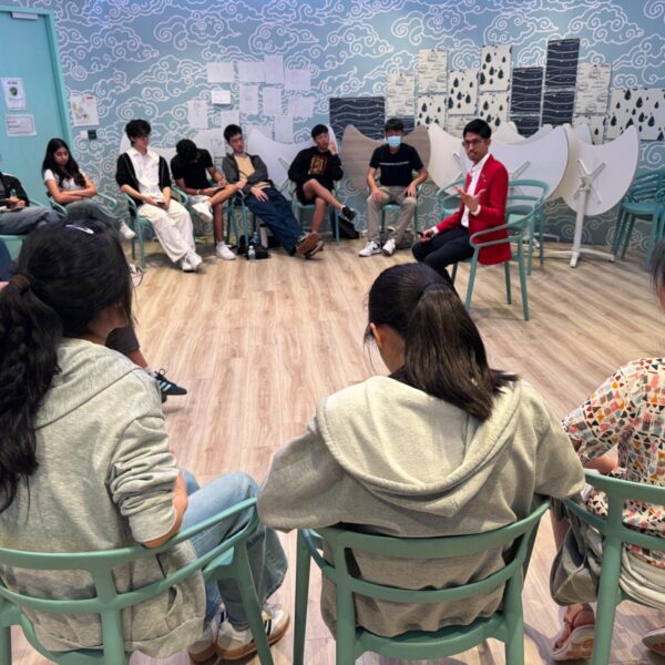 A group of students sitting in a circle listening to Hyder Taufik as trainer on Youth Leadership and Communicaton Camp