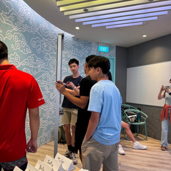 Students participate in a Youth Leadership and Communication workshop; one person writes on a whiteboard while others observe